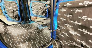 The inside of a vehicle with sound deadening being installed
