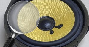 A magnifying glass examining a speaker
