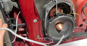 A car audio speaker being installed in a vehicle door