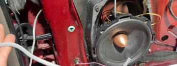 A car audio speaker being installed in a vehicle door